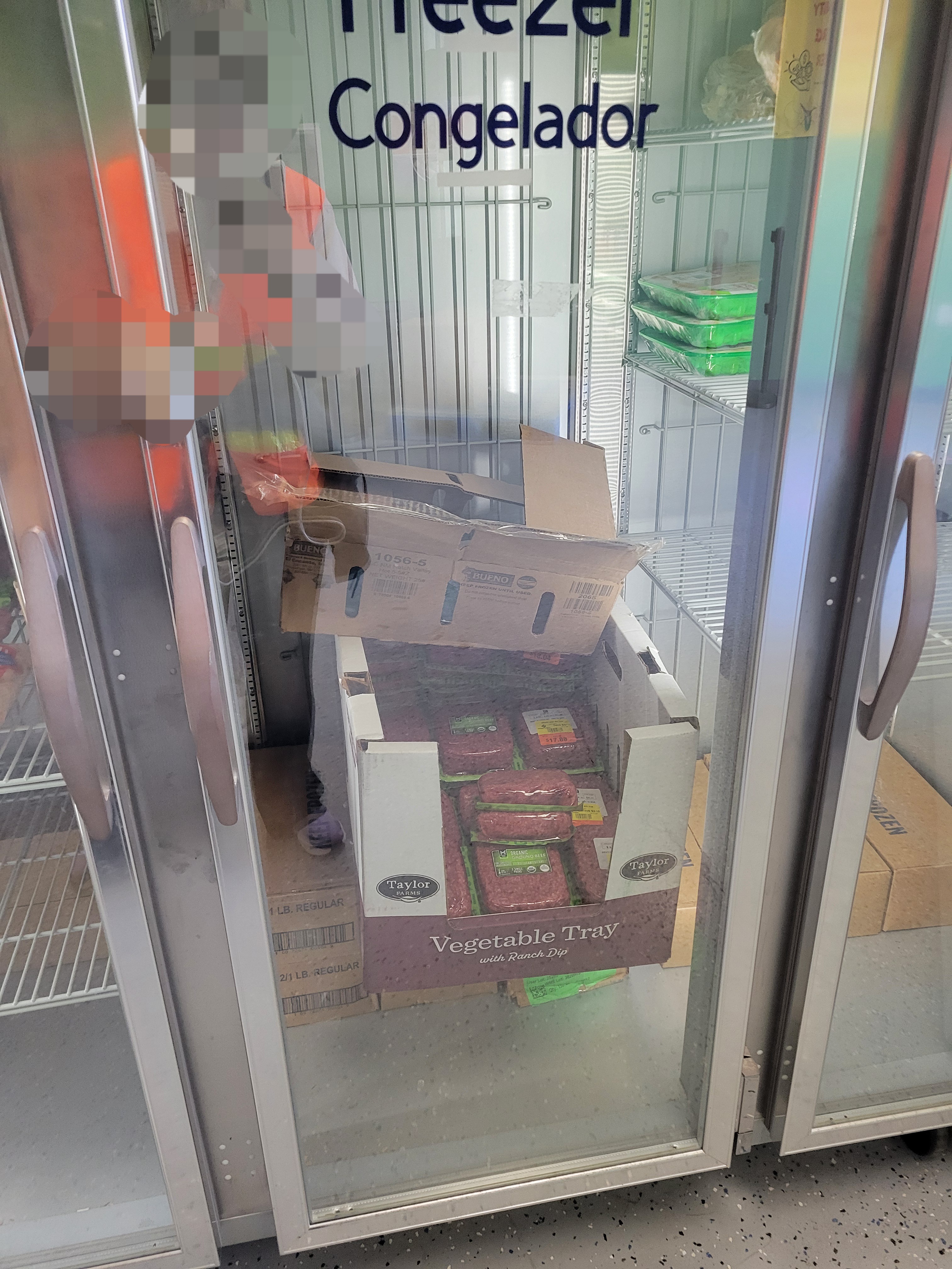 Cardboard tray filled with ground meat in a fridge.